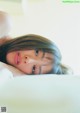 A woman laying on top of a bed with her eyes closed.