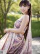 A woman in a floral dress posing for a picture.