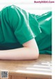 A person laying on a wooden table with their head on the table.