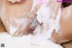 A woman is taking a bath with foam on her body.