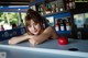 A woman leaning on a counter with an apple on it.