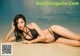 A woman in a black bikini laying on the beach.