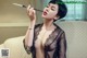 A woman in a black lingerie smoking a cigarette.