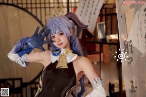 A woman with blue hair wearing a black dress and gloves.